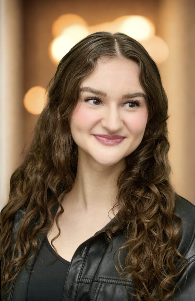 Victoria Brimble smiling in a professional warm-lit headshot